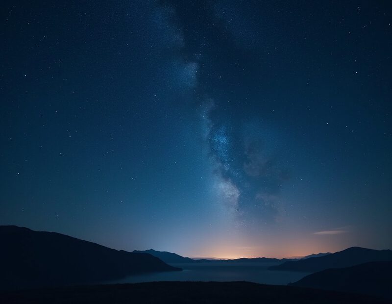 Klar natthimmel med många stjärnor över mörkt landskap
