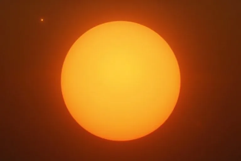 Solen lyser klart på en blå himmel och visar en enkel visuell förklaring av att solen är en stjärna.